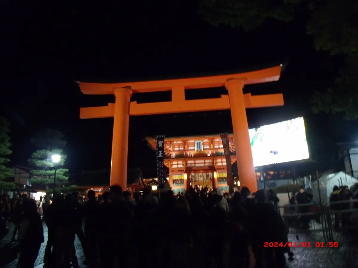 The entrance torii lit at night